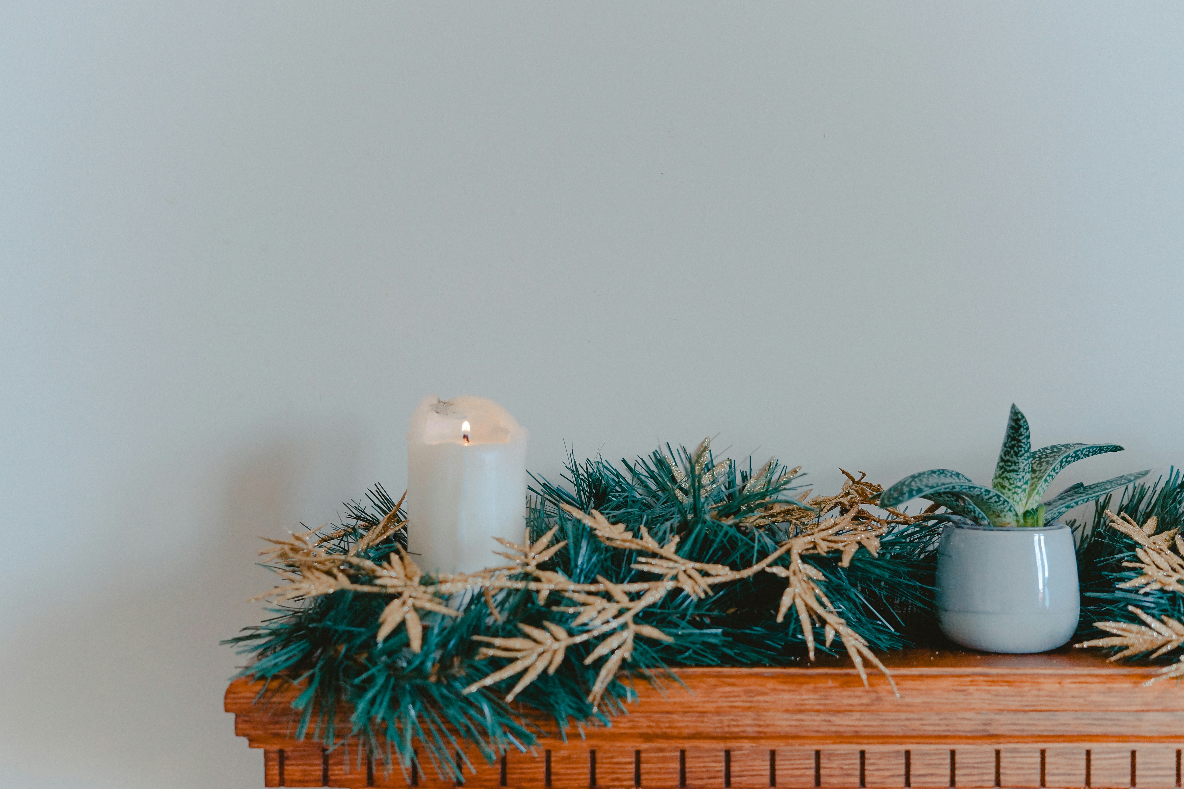 candle with garlands on shelf